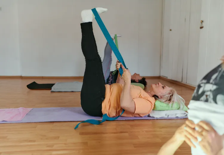 Étirement allongé de la bandelette ilio tibiale avec des sangles de yoga