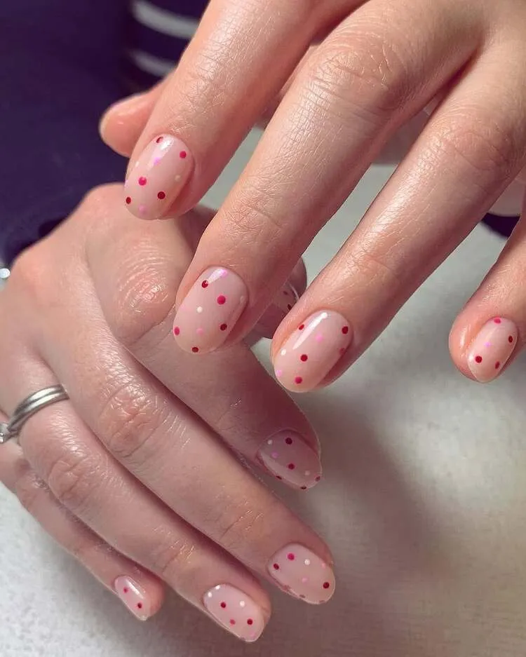 nail art nude enjolivé de points minuscules en rouge, rose et blanc