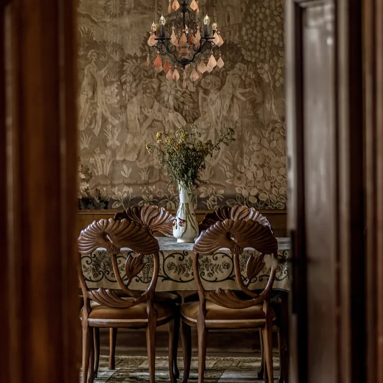 des chaises en bois vintage et une tapisserie murale vintage dans la salle à manger