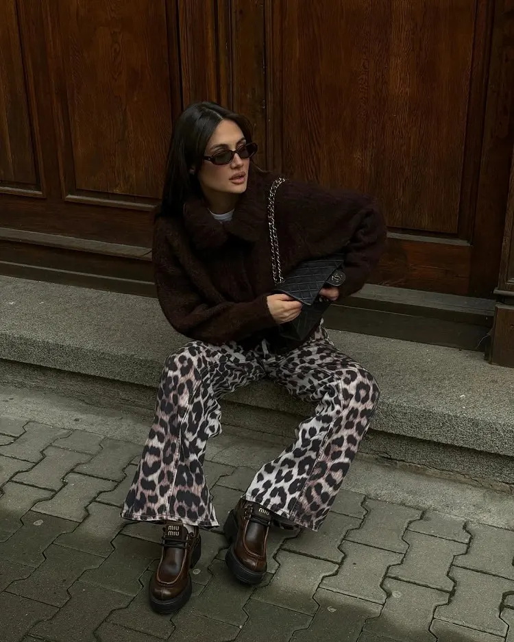 jeans léopard avec un pull marron, sac à main chanel et des chaussures miu miu