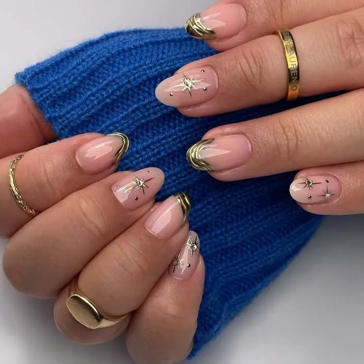 gold drip nails sur ongles courts arrondis avec des étoiles et des strass