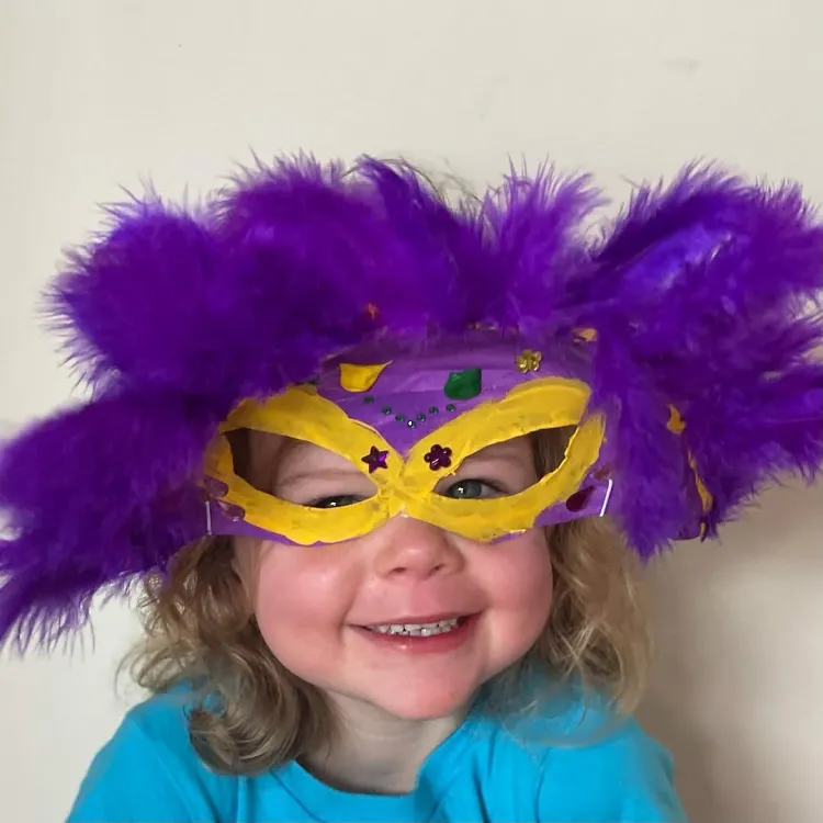 masque de mardi gras en violet et jaune décoré de plumes et perles colorées