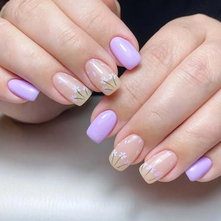 des ongles de couleur lavande associés à des fleurs printanières délicates