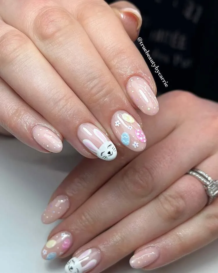 une jolie combinaison de lapin mignon et d'œufs colorés sur des ongles en amande