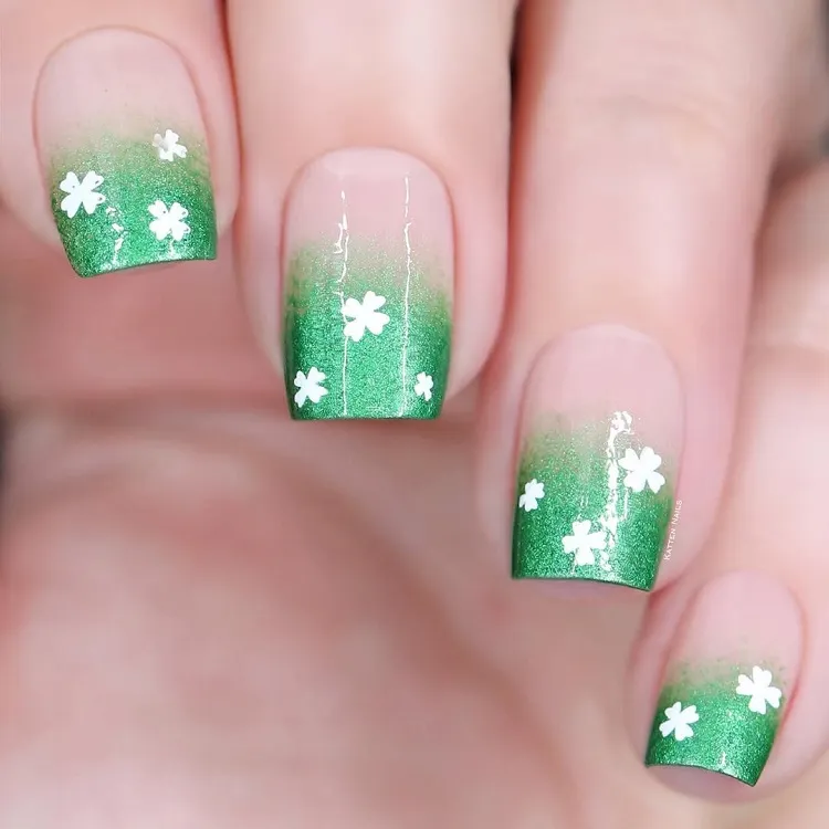 Manucure vert ombré avec des trèfles à quatre feuilles blancs