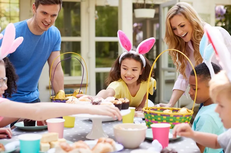 parents avec enfants portant des oreilles de lapin appréciant le déjeuner de pâques