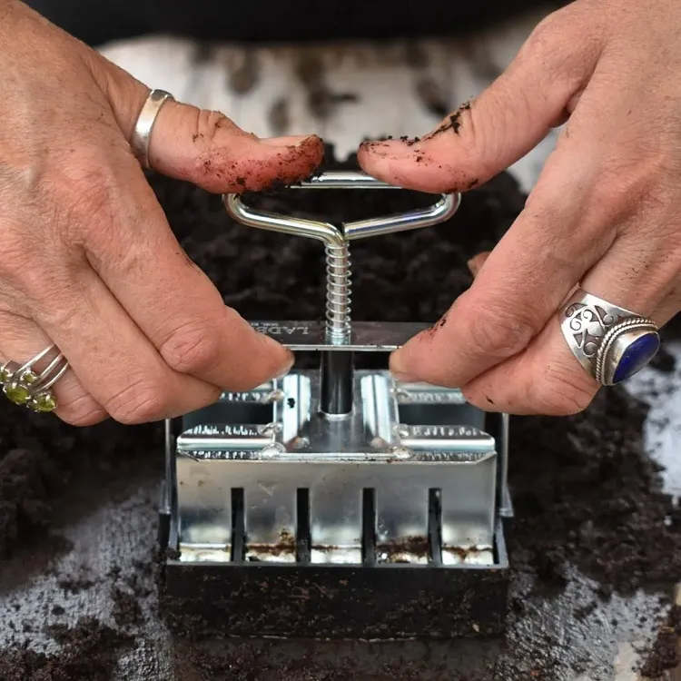 un outil soil blocker permet de façonner des blocs de terre compacts