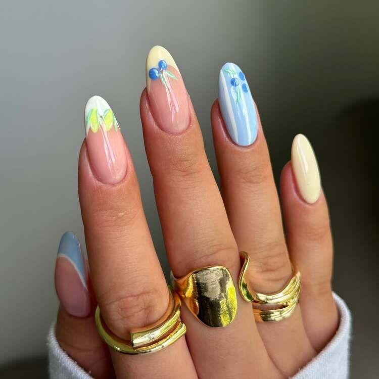 des ongles aux teintes pastel décorés de feuilles et de myrtilles délicates un rendu frais et fruité