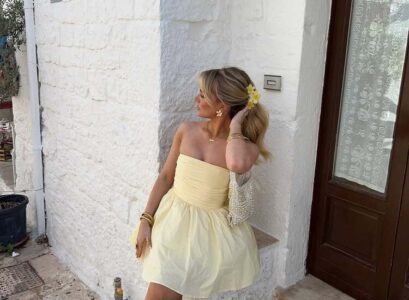 les accessoires dorées renforcent l'allure chic de la robe bustier jaune pâle qui sent bon l'été