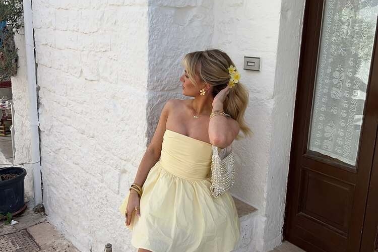 les accessoires dorées renforcent l'allure chic de la robe bustier jaune pâle qui sent bon l'été