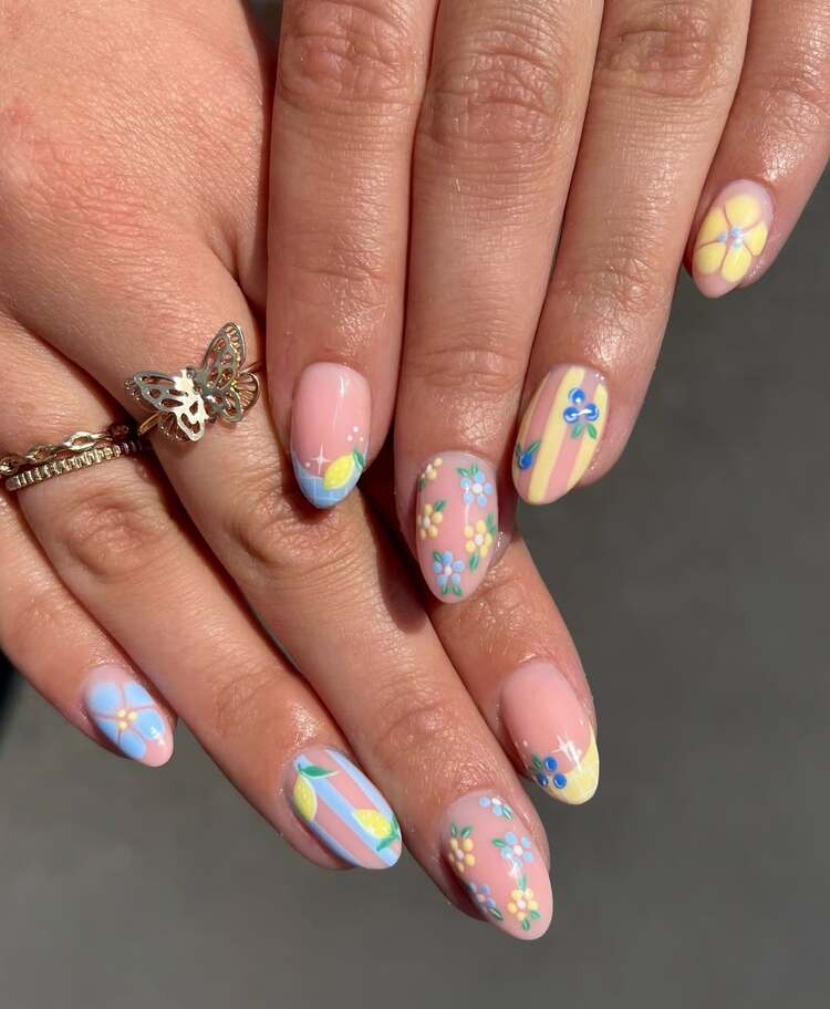 une explosion de couleurs pastel sur fond rose qui donne à la manucure un look joyeux et festival