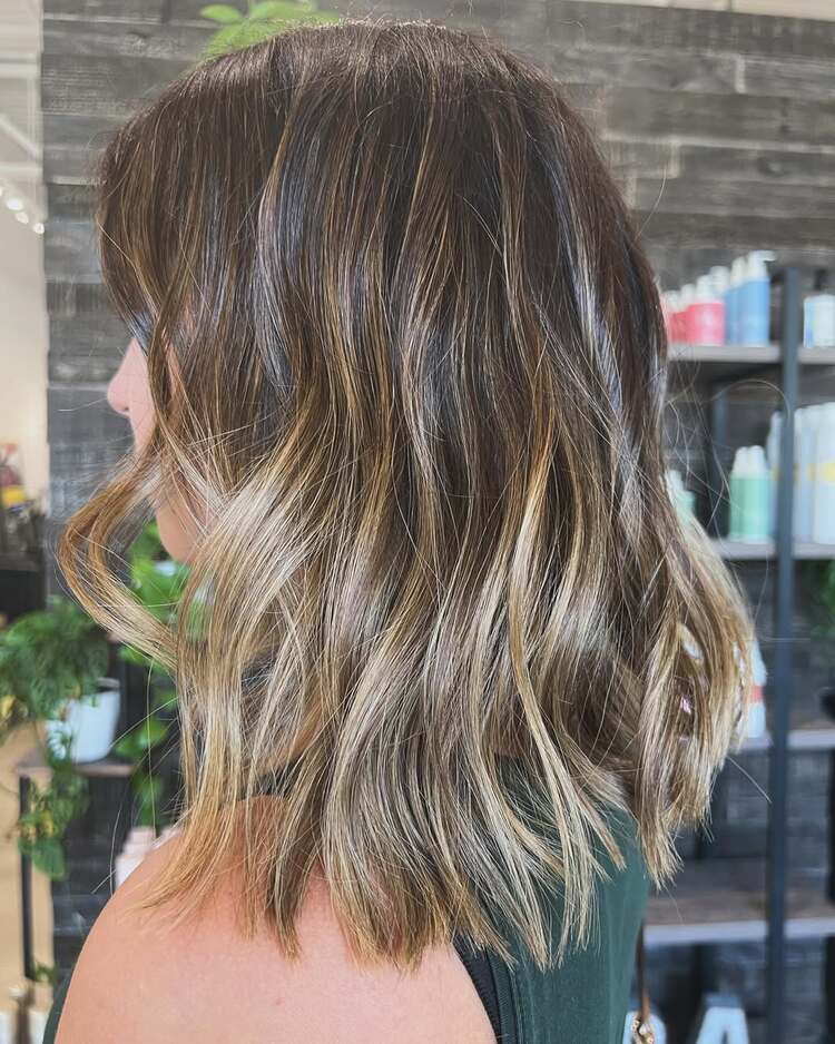 carré clavicule subtilement dégradé et illuminé par un balayage blond miel