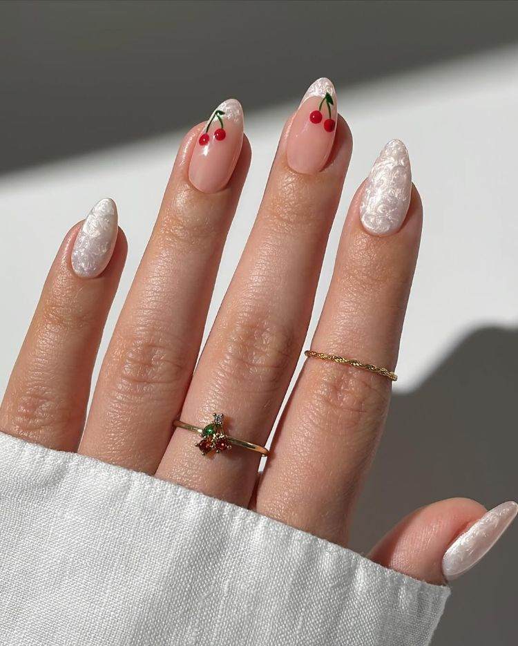 manucure blanc nacré sur ongles en amande avec nail art cerise
