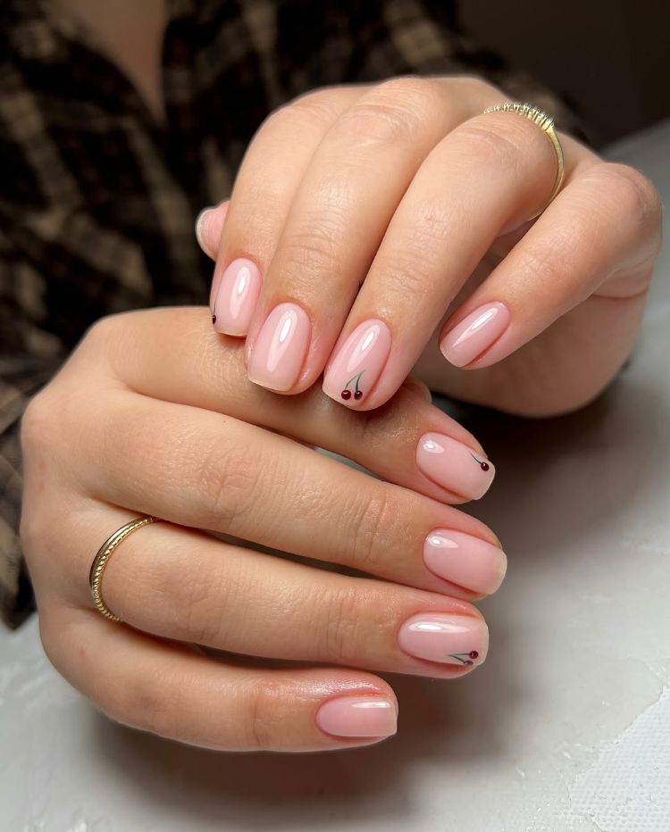 manucure minimaliste nude avec nail art cerise délicat