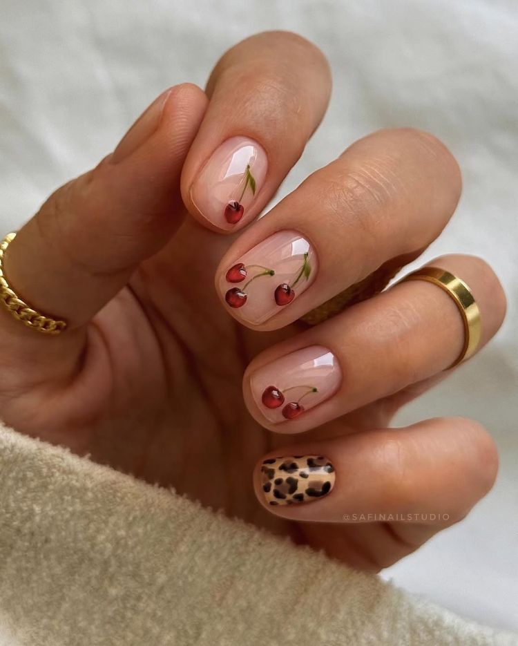 manucure nude sur ongles courts avec nail art cerise et imprimé léopard