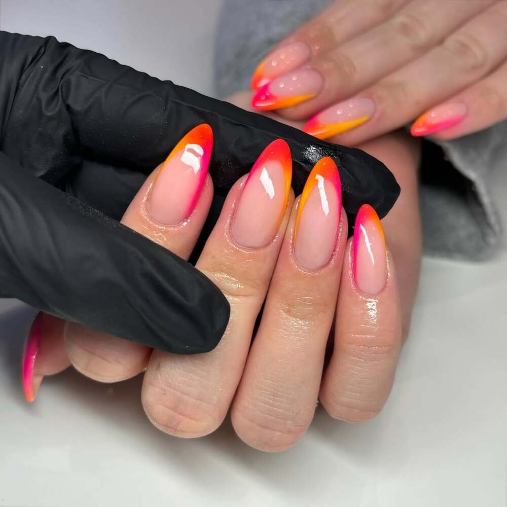 Des ongles à effet ombré aux couleurs vibrantes, mélangeant rose fluo et orange néon, idéals pour un été pétillant et audacieux