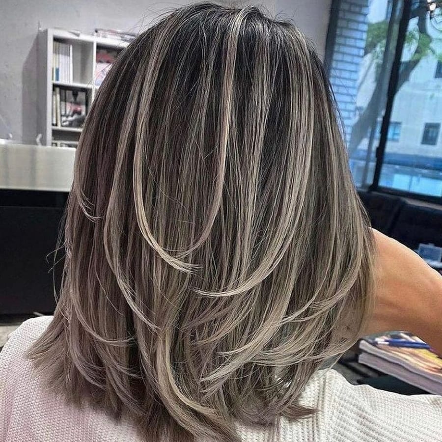 Le look sel et poivre mélange de mèches grises et de cheveux foncés