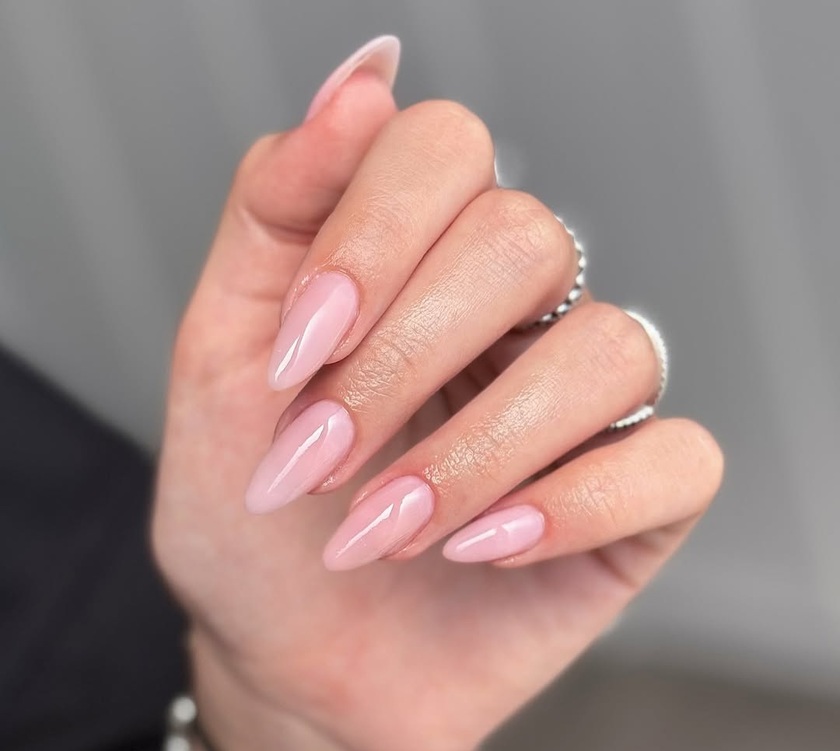 Ongles en amande sublimés par une nuance rose pâle translucide qui illustrent parfaitement la tendance des rose water nails