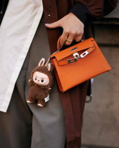accessoire Labubu accroché à un sac à main Hermès orange