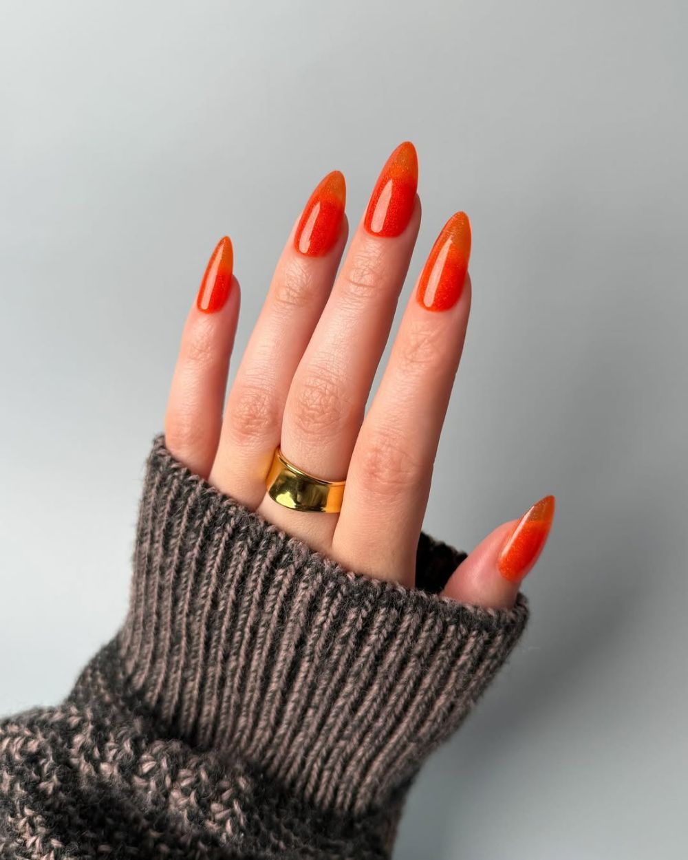 des ongles en amande orange vif inspirés par le cocktail d'été Aperol Spritz