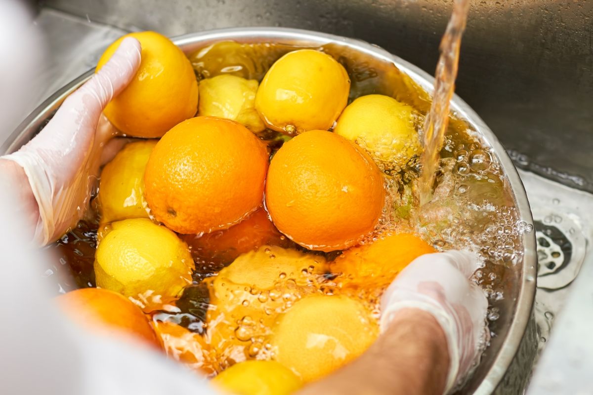 laver des citrons dans un bol d'eau pour enlever les pesticides et les saletés