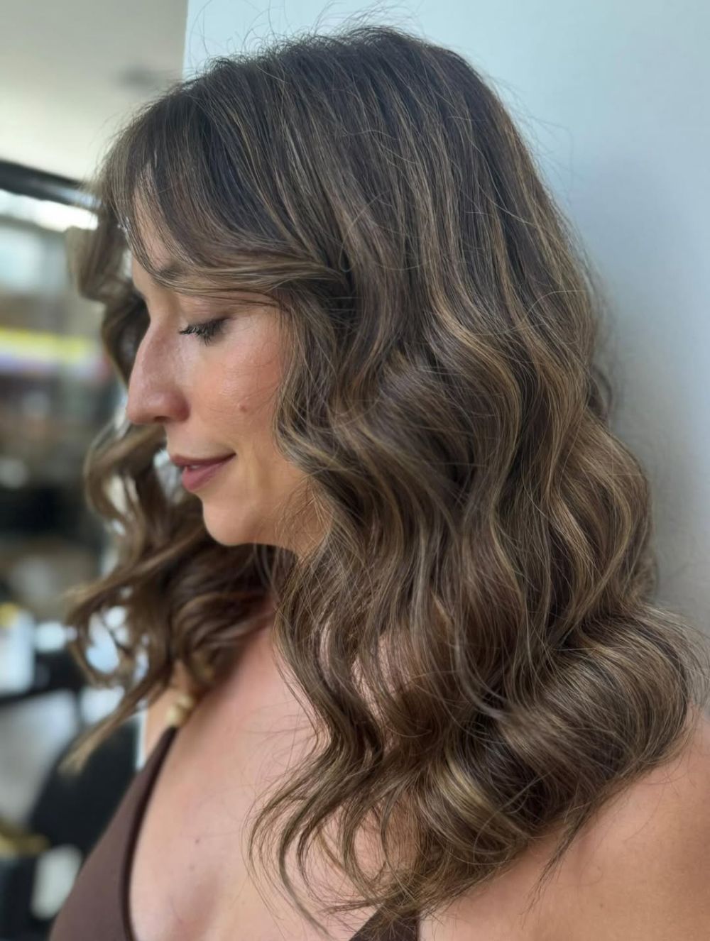 le balayage brun cendré est une coloration tendance qui met en valeur les cheveux gris après 50 ans