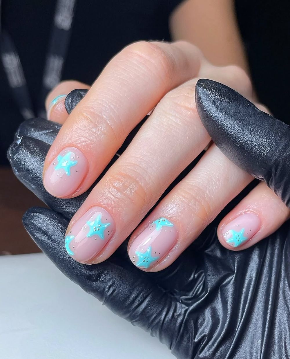 nail art étoile de mer en bleu pastel sur ongles courts nude