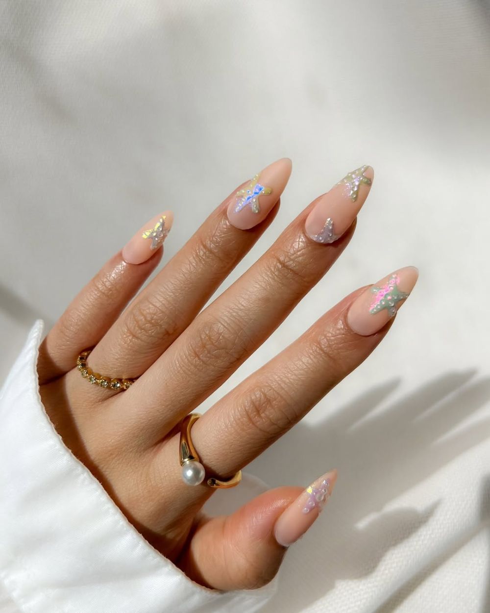 nail art étoiles de mer colorées en 3D sur des ongles nude