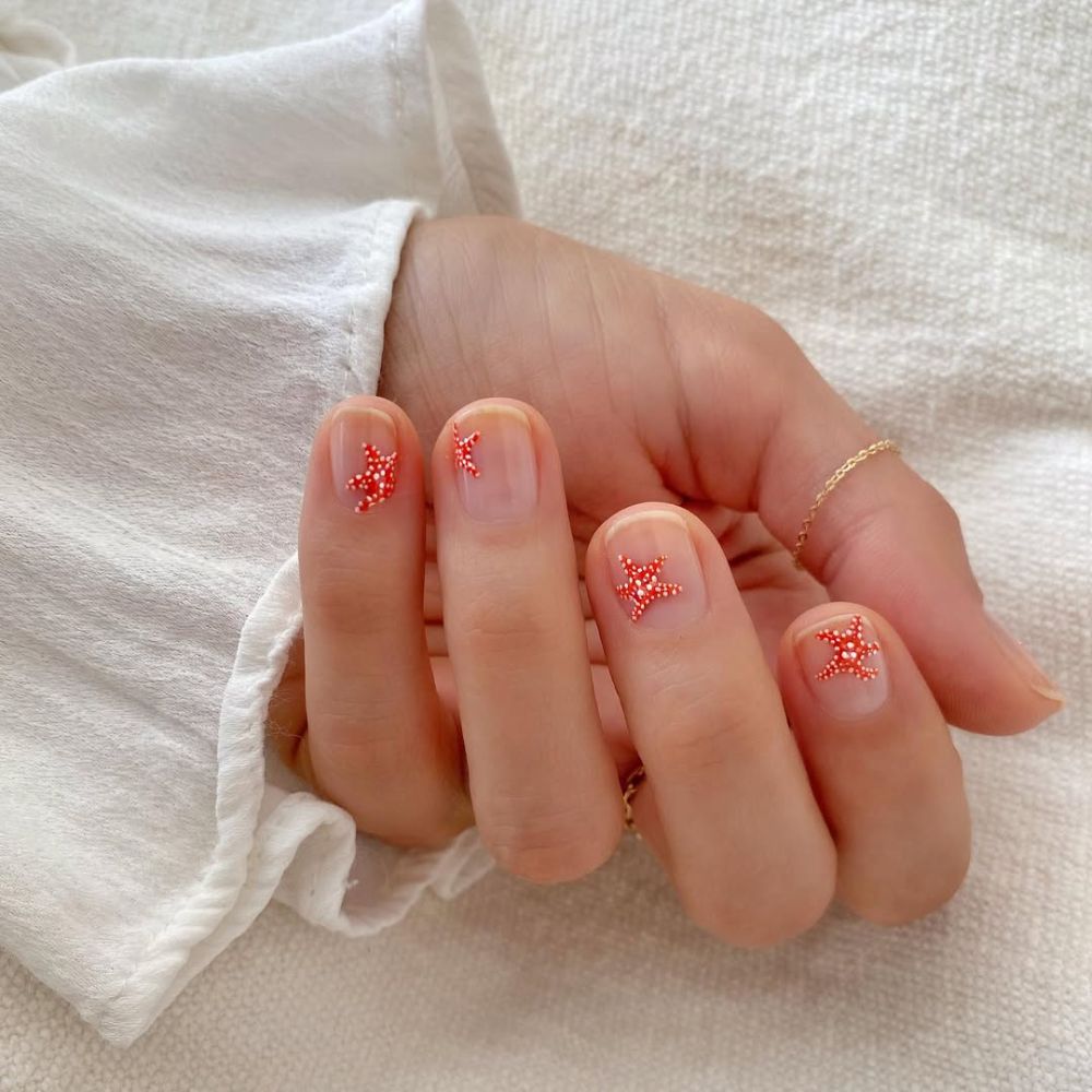 ongles courts nude sublimés par un nail art étoiles de mer