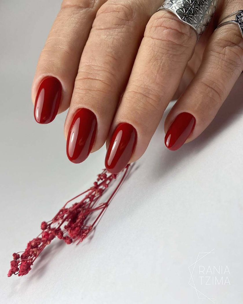 Le rouge profond à reflets chauds flirte avec le terracotta pour une manucure sophistiquée, idéale pour la saison