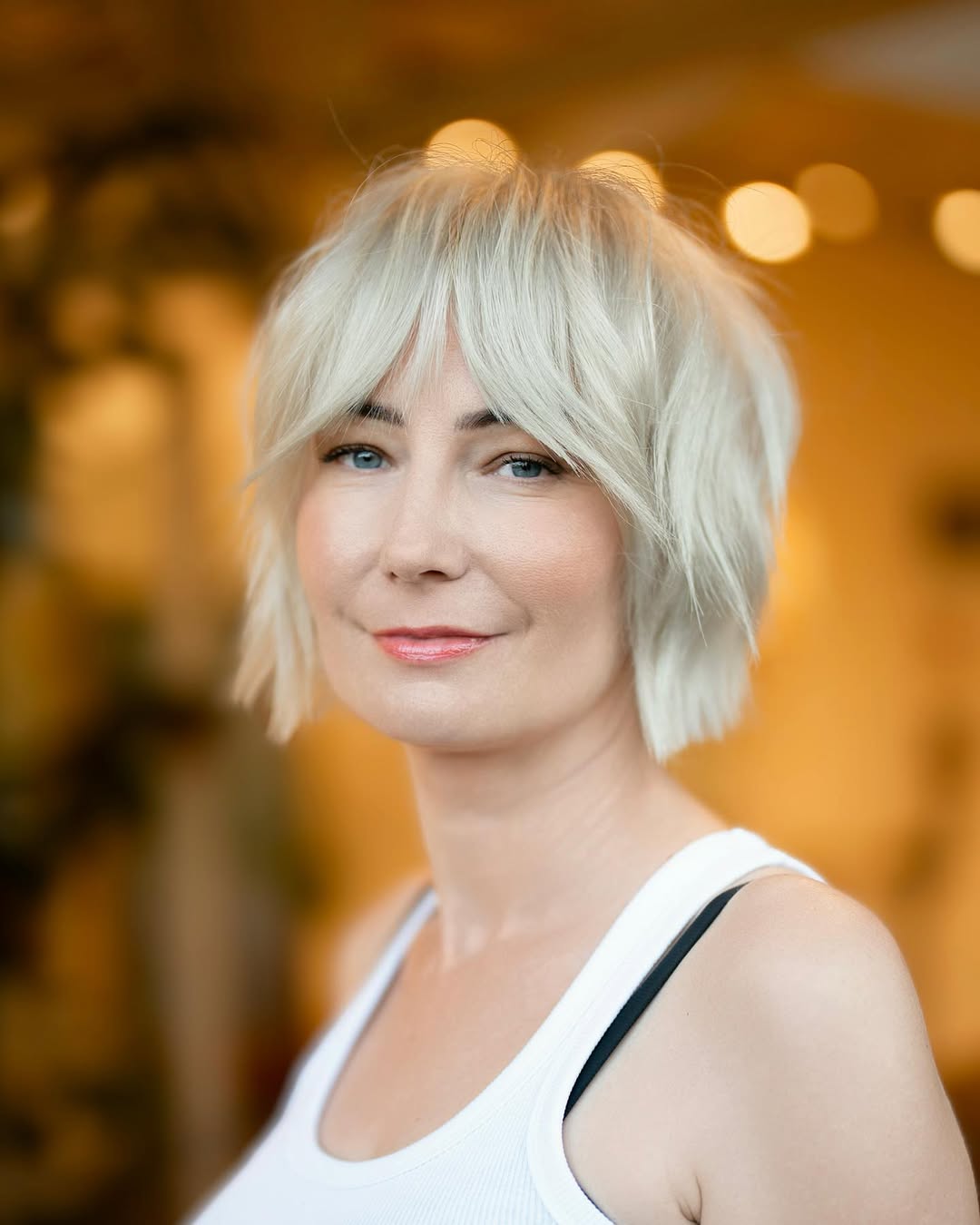 carré dégradé avec frange rideau et coloration blond polaire