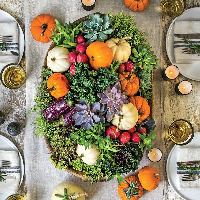 centre de table végétal pour l'automne composé de mini citrouilles plantes succulentes et aubergines