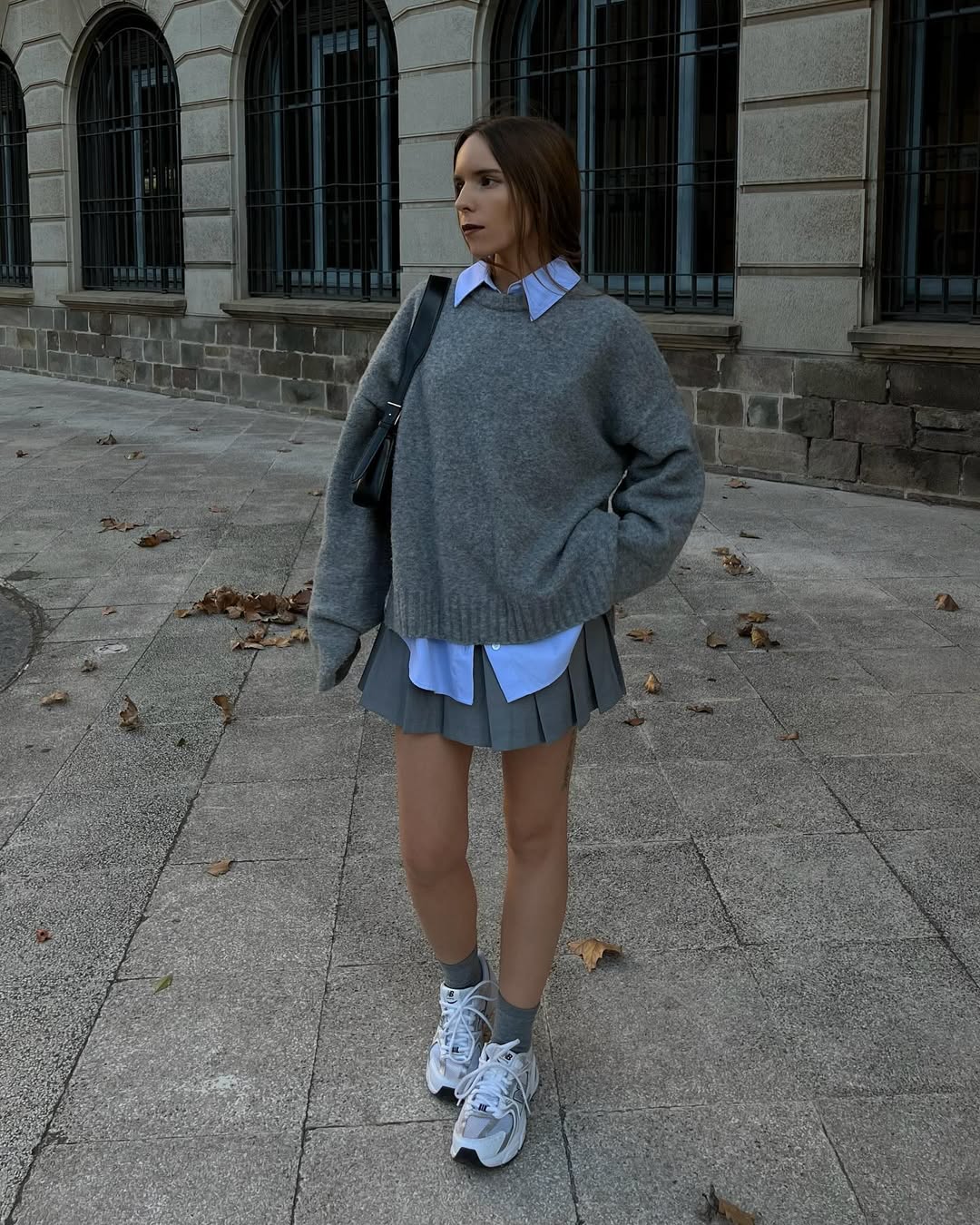 layering automnal-porter un chemisier long sous un pull oversize gris et une jupe de tennis assortie