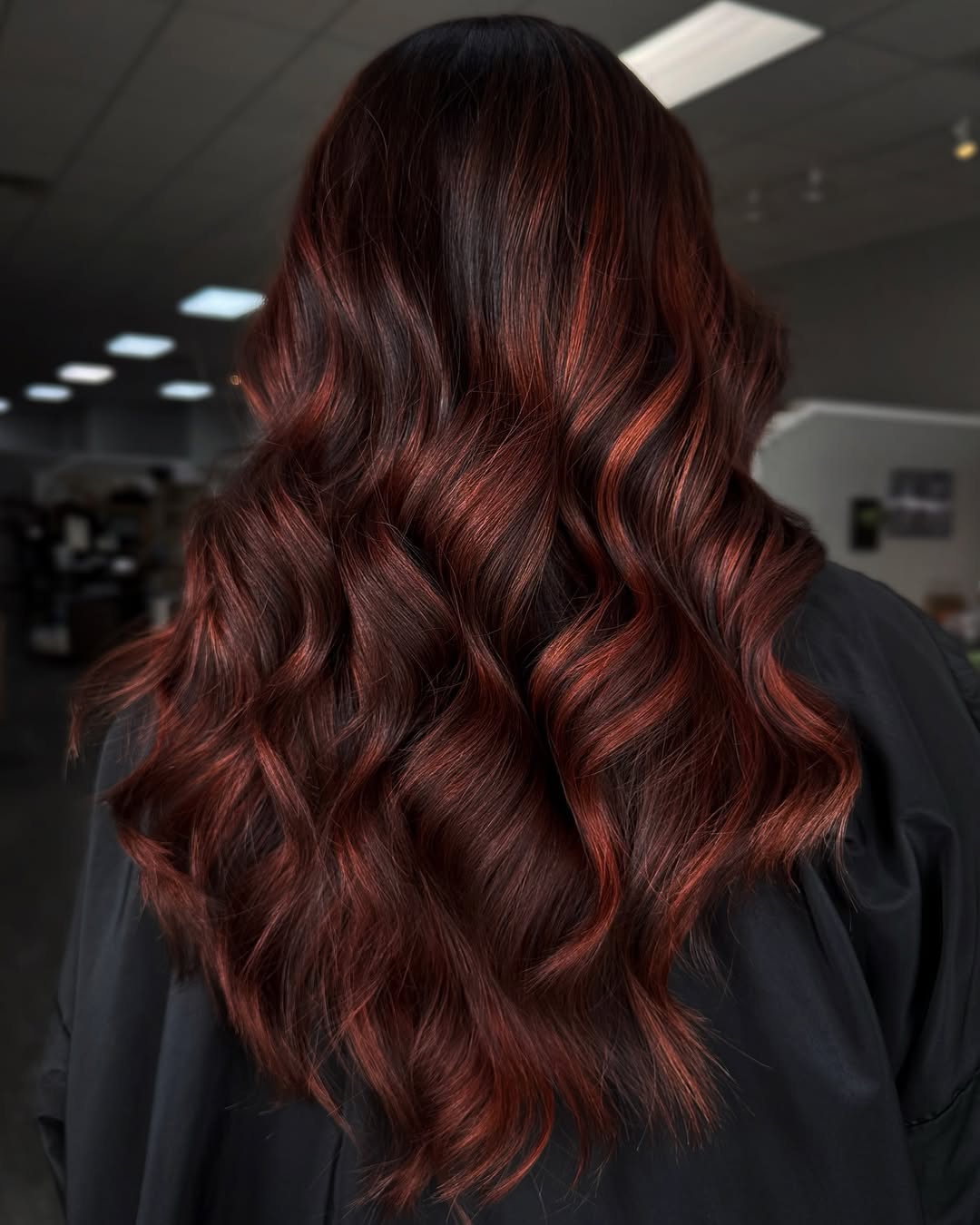 un superbe balayage rouge auburn sur des cheveux bruns longs