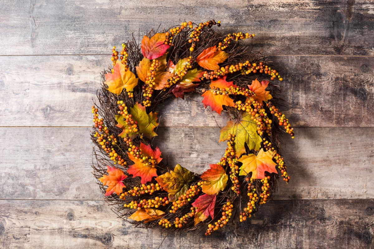 couronne automne décorative en jaune et orange réalisée avec des feuilles et baies artificielles