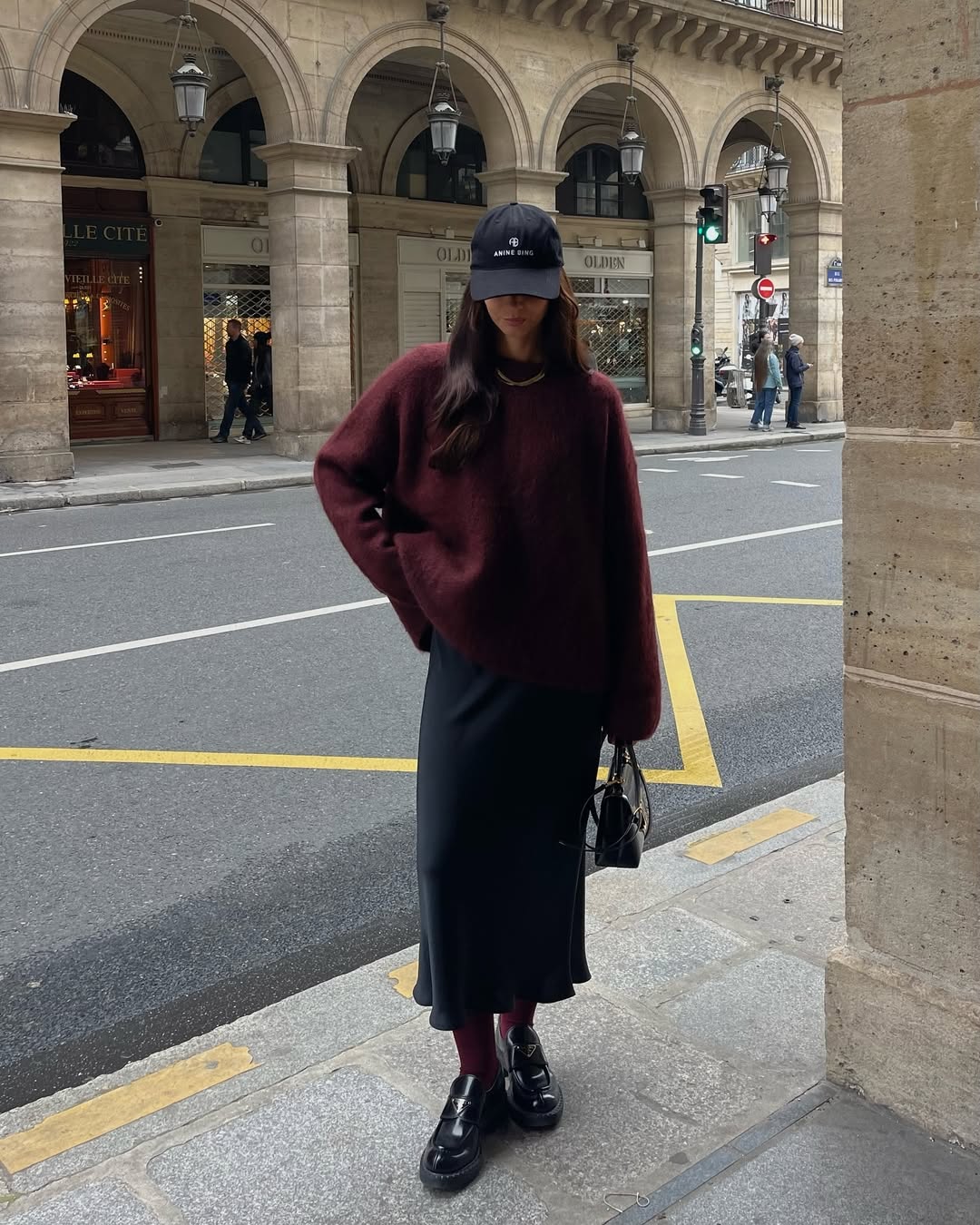 pull burgundy oversize à porter avec une jupe en satin noire