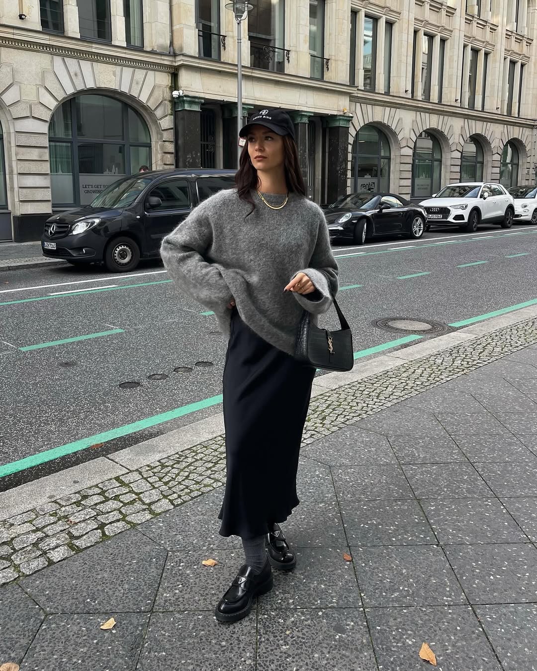 tenue cozy chic automne 2025-la jupe en satin longue associée à un pull gris oversize et mocassins à talons épais