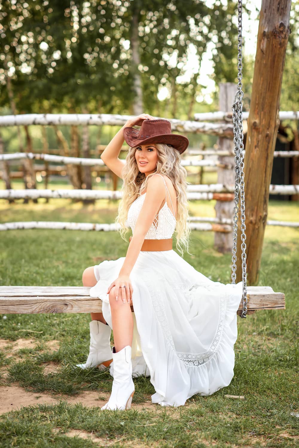 costume femme cowgirl halloween 2025 chapeau de cowgirl brun robe blanche fluide bottes blanches à talons