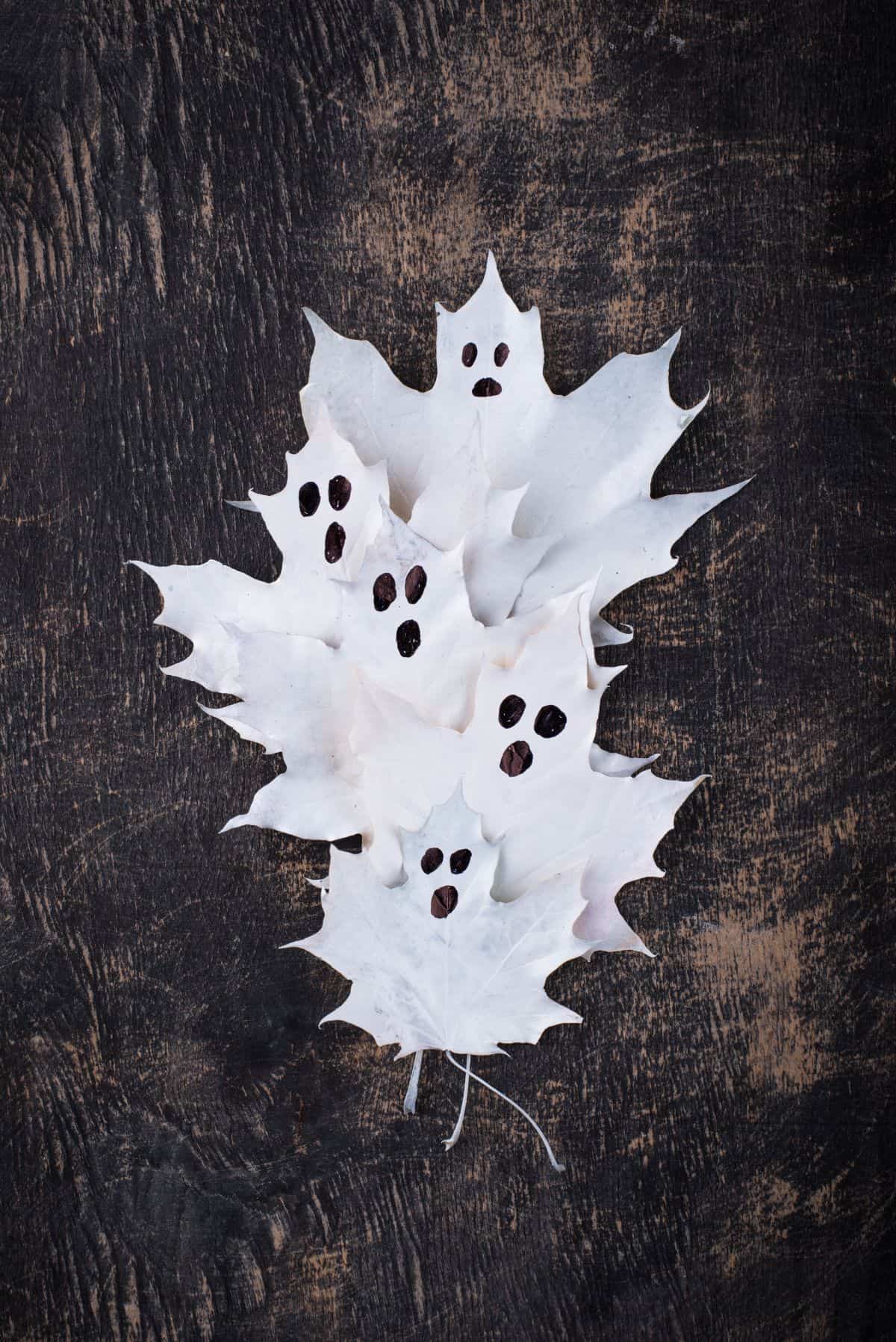 des feuilles automnales repeintes en blanc et détournées en fantômes Halloween insolites