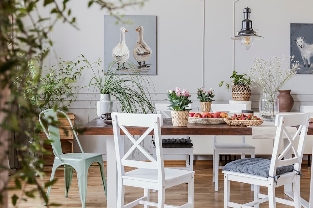 salle à manger ferme moderne table en bois chaises blanches à dossier croisé chaise métallique vert pâle luminaire suspendu industriel