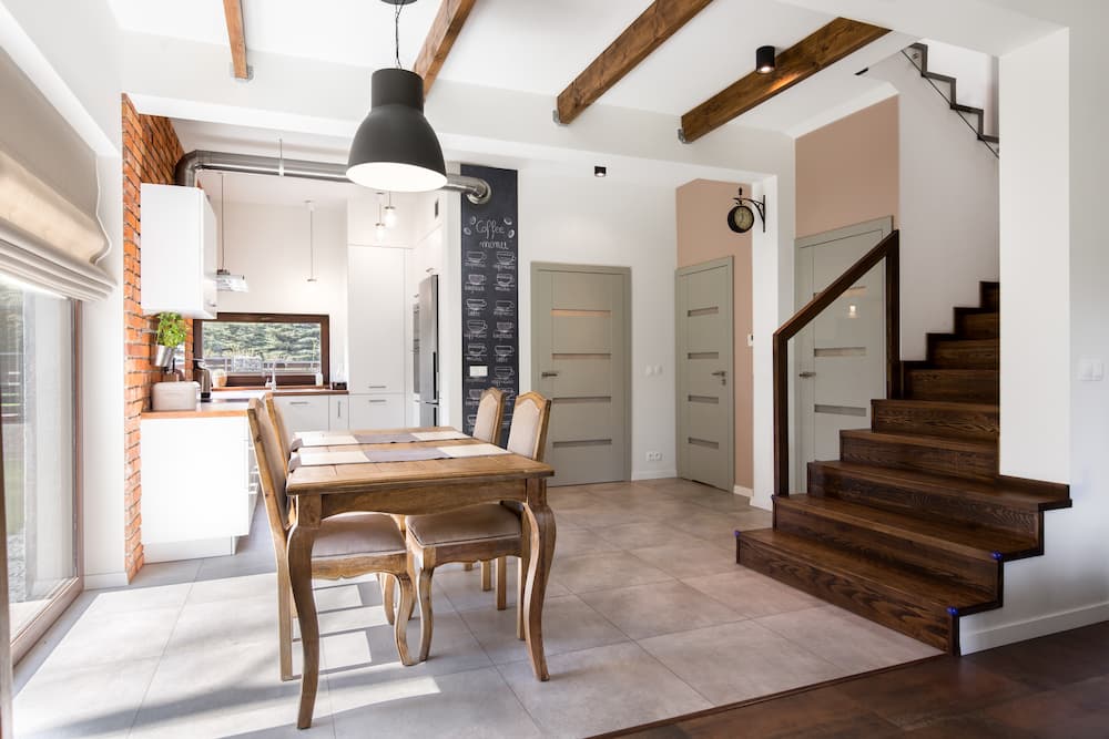 salle à manger rustique chic modern farmhouse table en bois avec quatre chaises classiques mur en briques plafond poutres apparentes