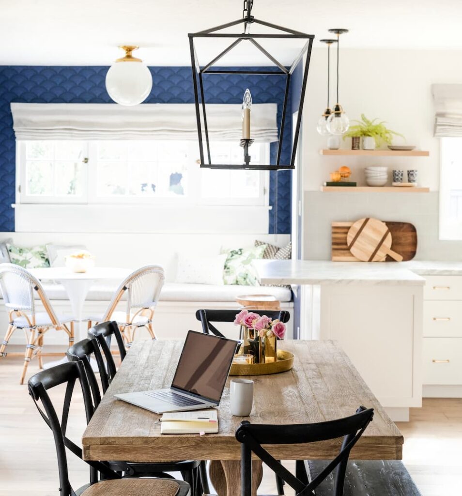 salle à manger style ferme moderne table en bois chaises noires mur bleu texturé étagères ouvertes
