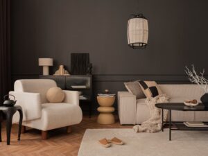 salon cosy et élégant murs peints en marron chocolat couleur année 2026 canapé et fauteuil en tissu beige crème, table basse ronde noire en métal