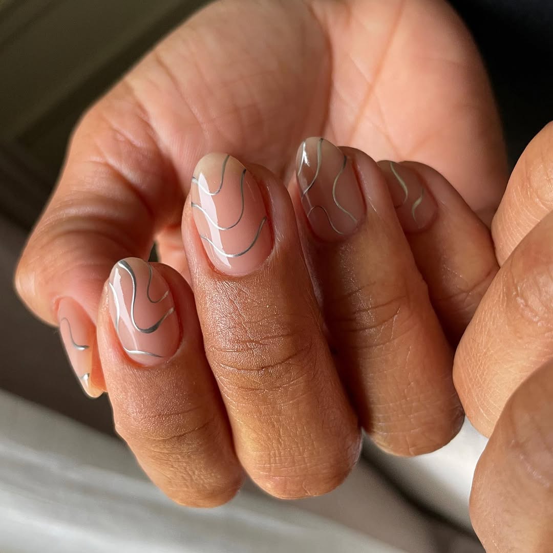 De fines lignes argentées façon swirl nails pour une manucure élégante et discrète