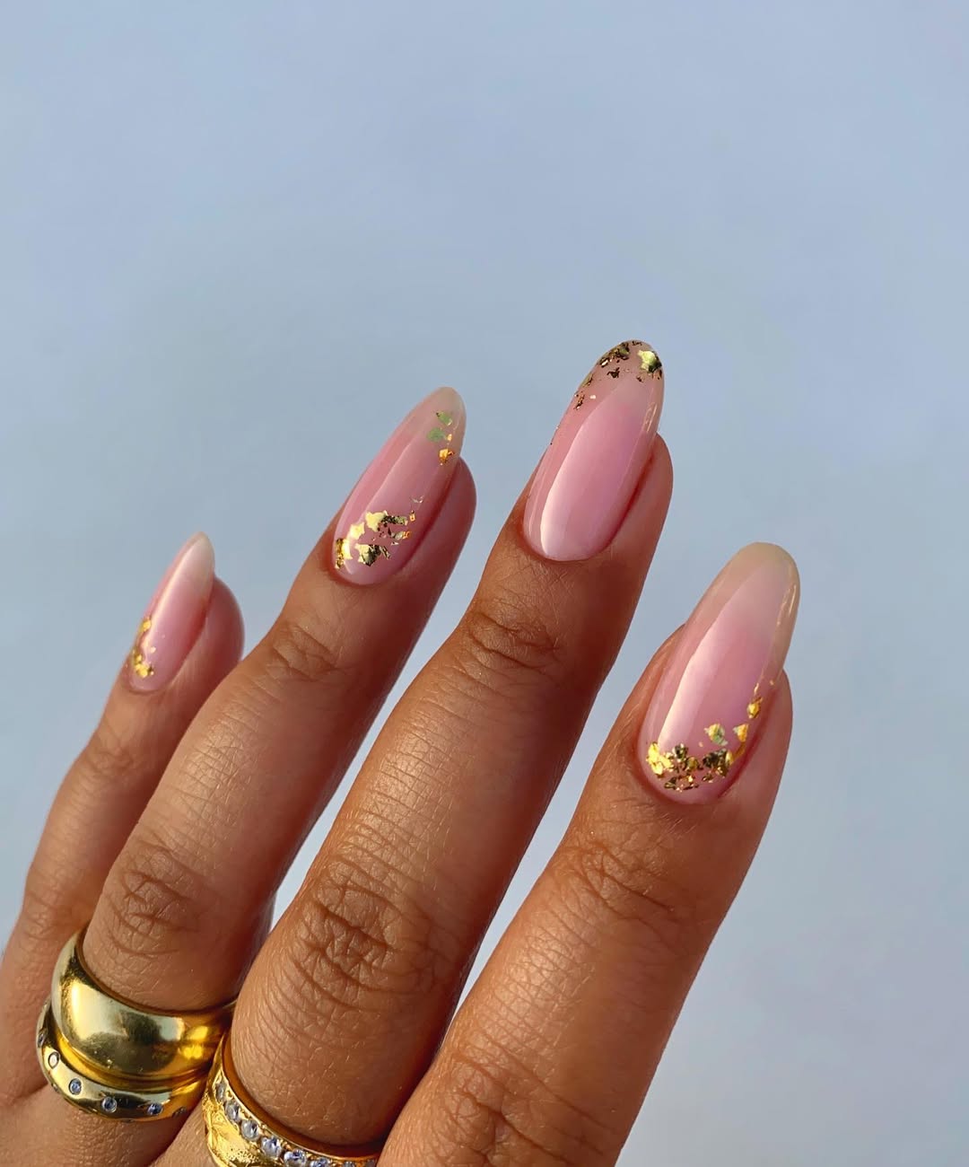 Ongles en amande, base rose légère et feuilles dorées en bordure