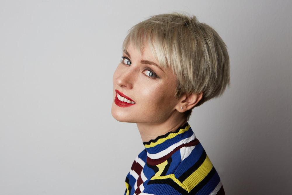 coupe courte pixie cheveux blonds lisses et effilés avec frange balayée sur le côté