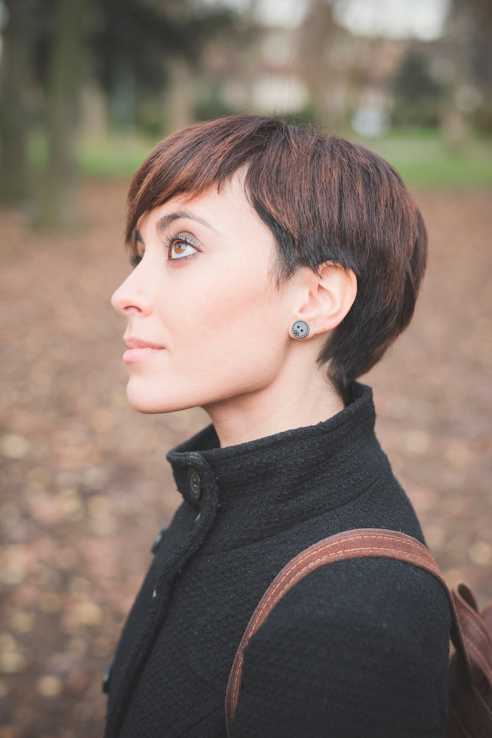 coupe courte pixie plus longue sur le dessus et à l’avant cheveux lisses brun foncé frange latérale