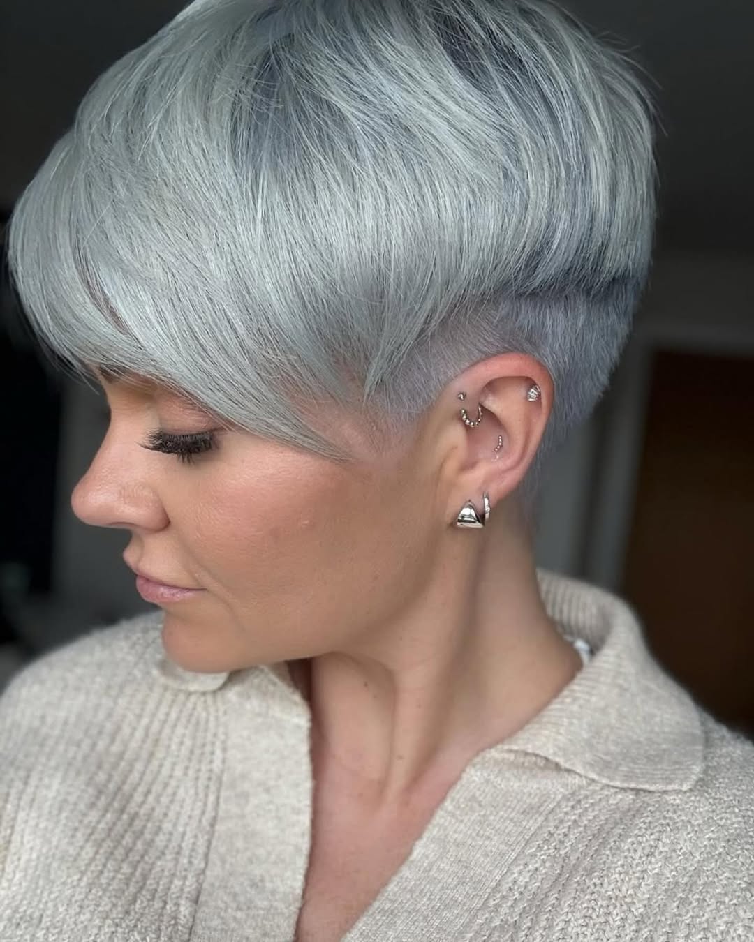 coupe pixie longue avec côtés et nuque dégagés dessus plus long mèche balayée sur le côté