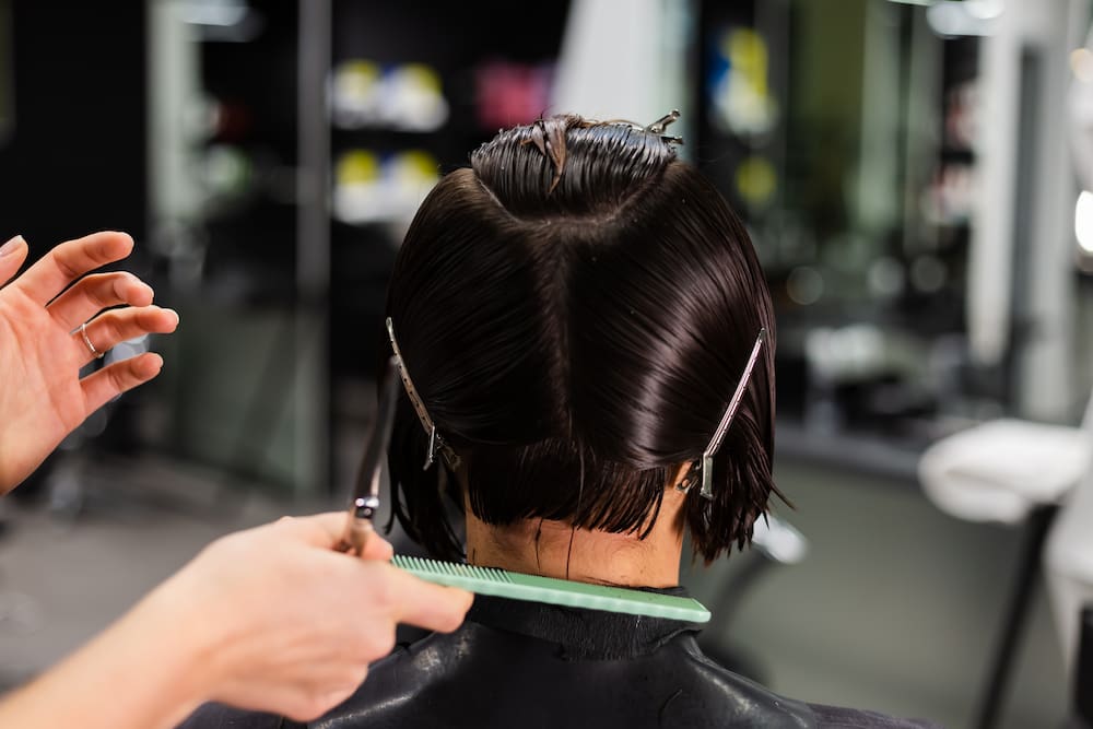 femme en plein processus de coupe courte chez le coiffeur