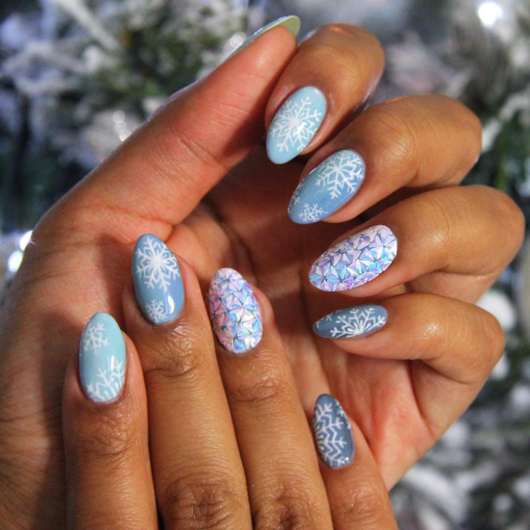 Des ongles en amande parsemés de flocons de neige délicatement dessinés